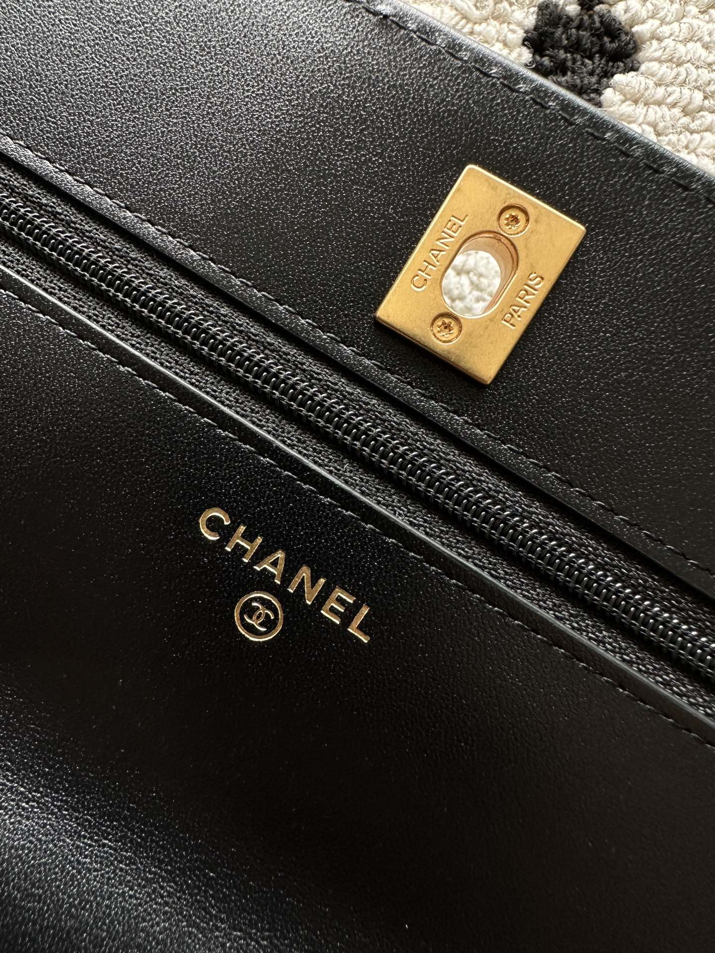 Black leather bag lining label with gold-tone Chanel and zipper track