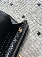 Black bag zipper detail with gold-tone pull and Chanel logo charm