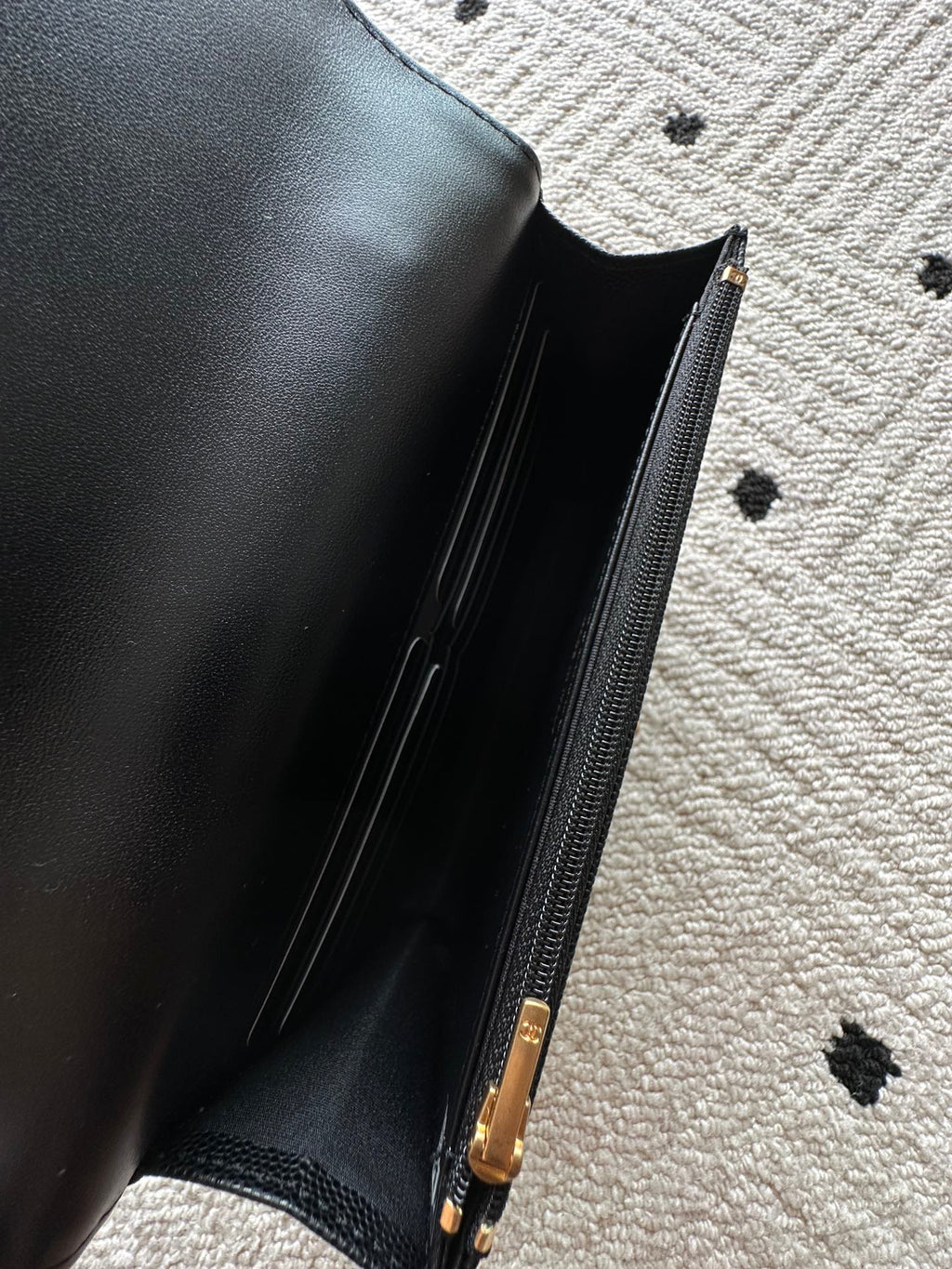 Black leather bag interior with visible zipper and gold-tone pull
