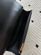 Black leather bag interior with visible zipper and gold-tone pull