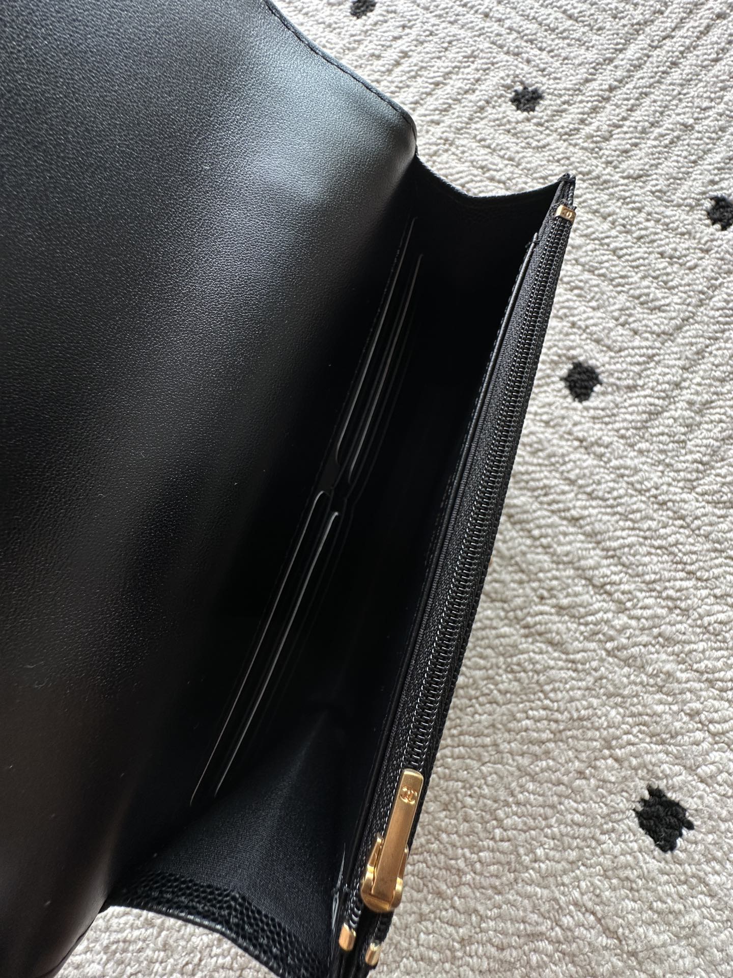 Black leather bag interior with visible zipper and gold-tone pull
