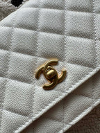 Chanel white quilted bag close-up of gold CC turn-lock on flap