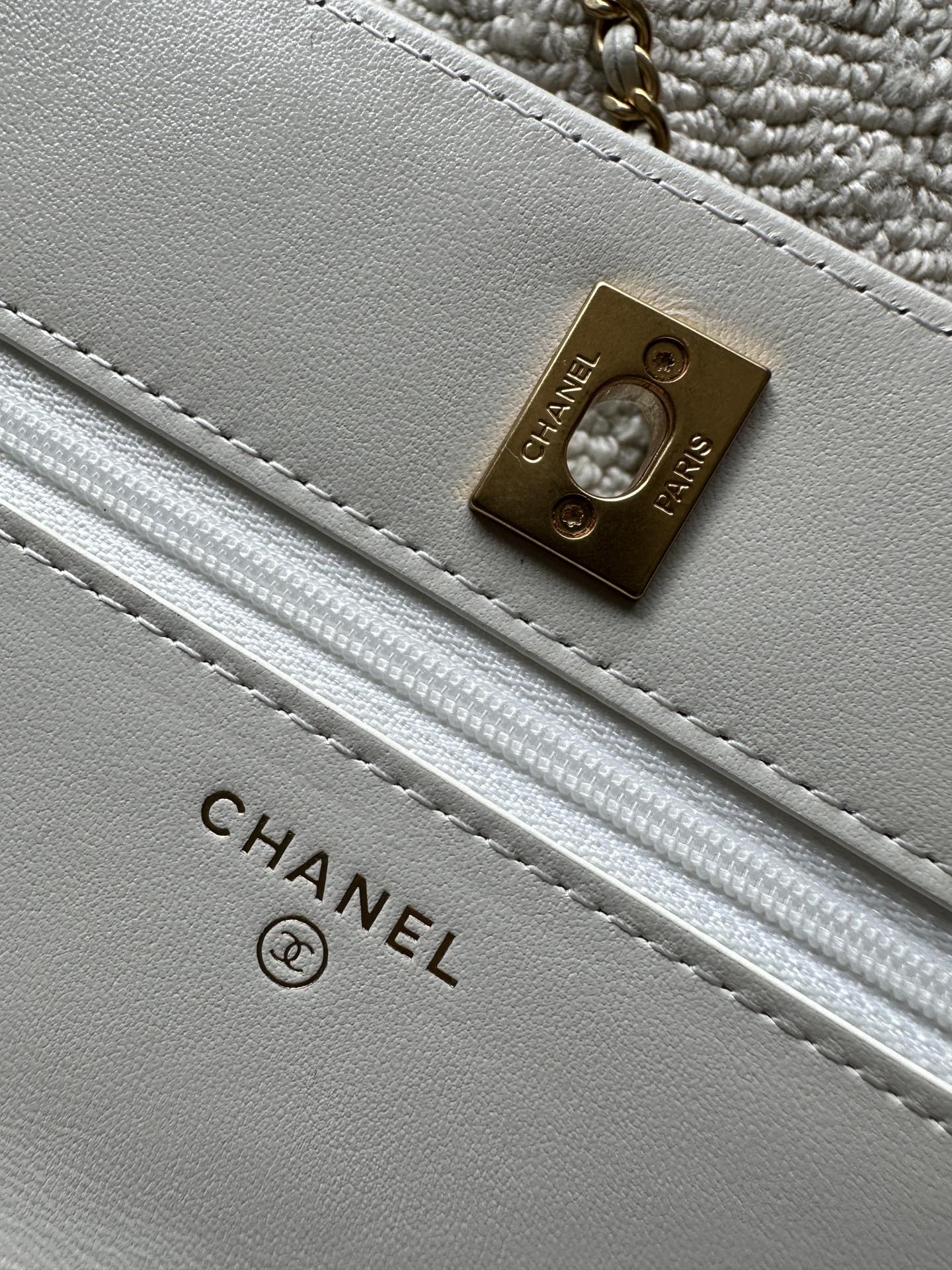 Chanel white bag close-up of CHANEL PARIS label on gold metal plaque