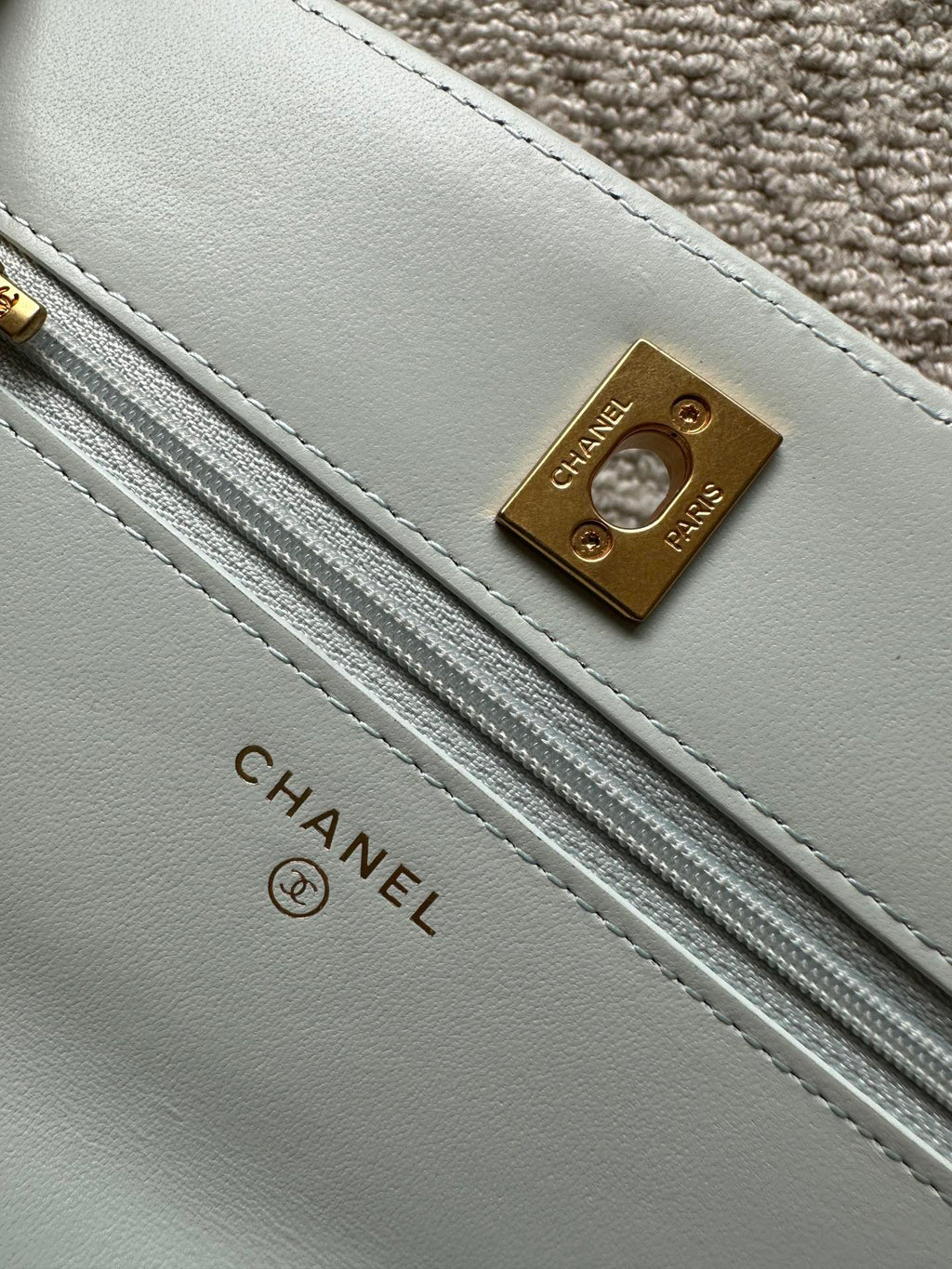 Chanel light blue leather strap panel with gold logo plate and long stitching
