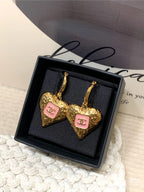 Gold-tone heart drop earrings with pink enamel logos in Chanel gift box.