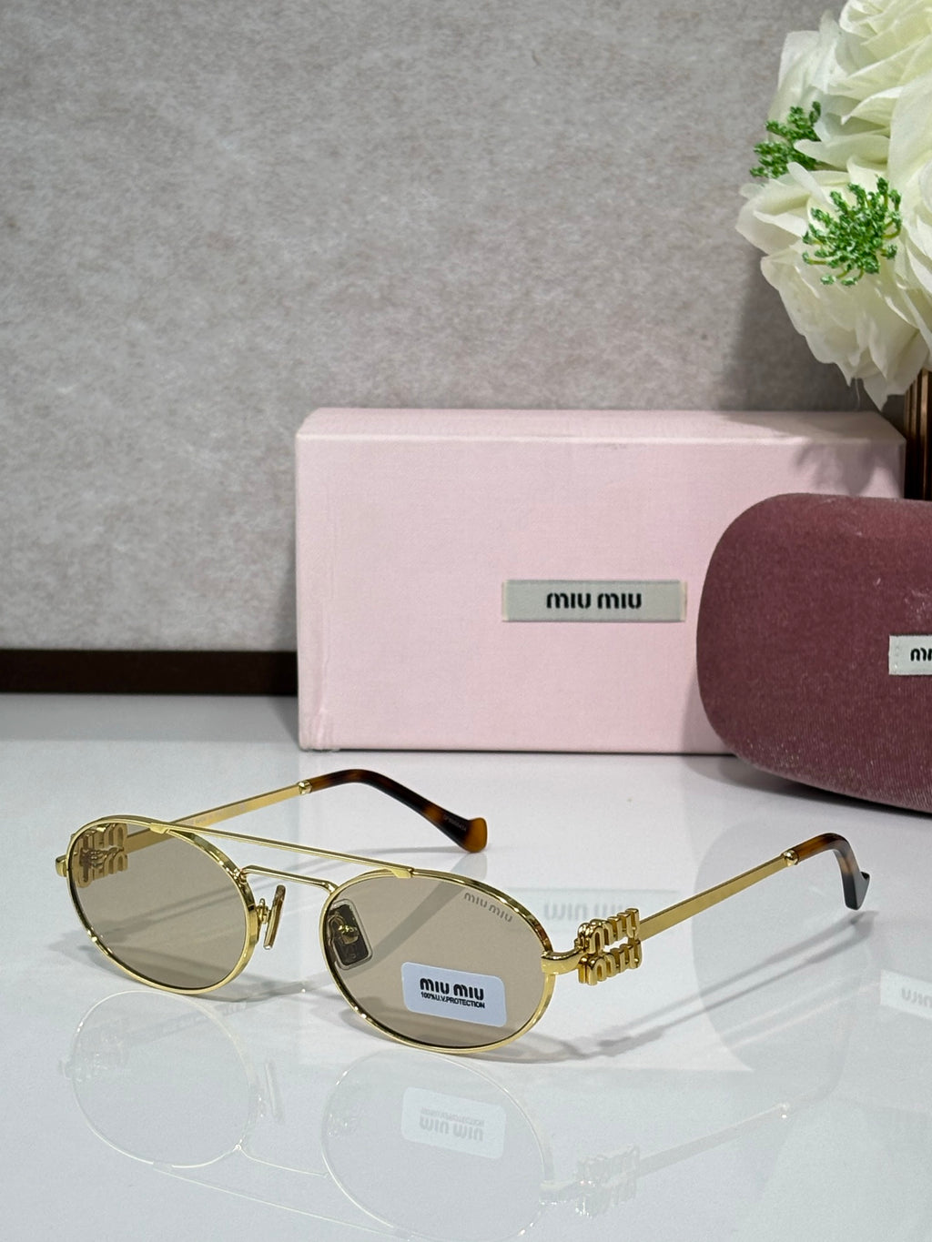 Gold metal round sunglasses with light-tinted lenses and black temple tips