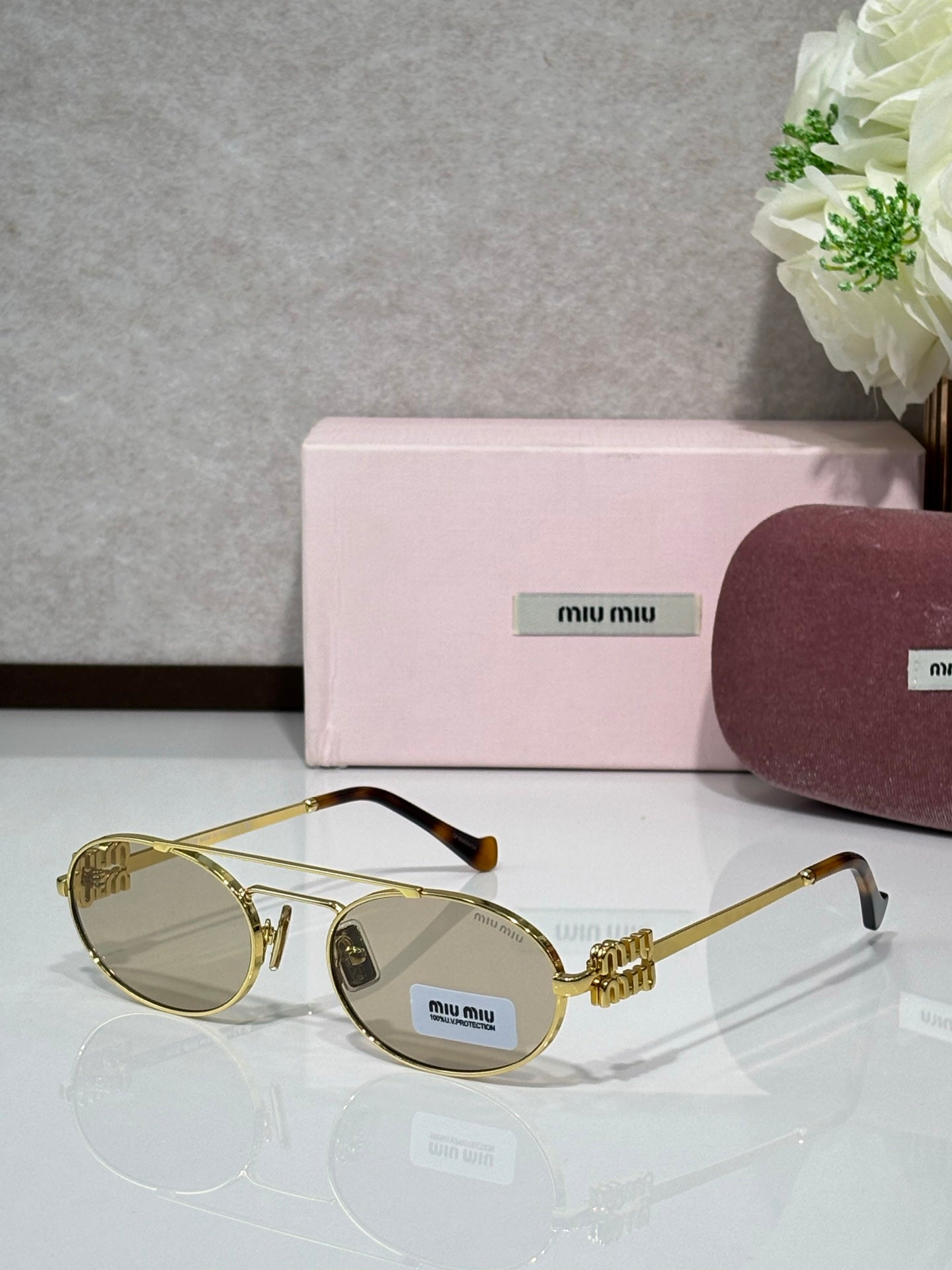 Gold metal round sunglasses with light-tinted lenses and black temple tips