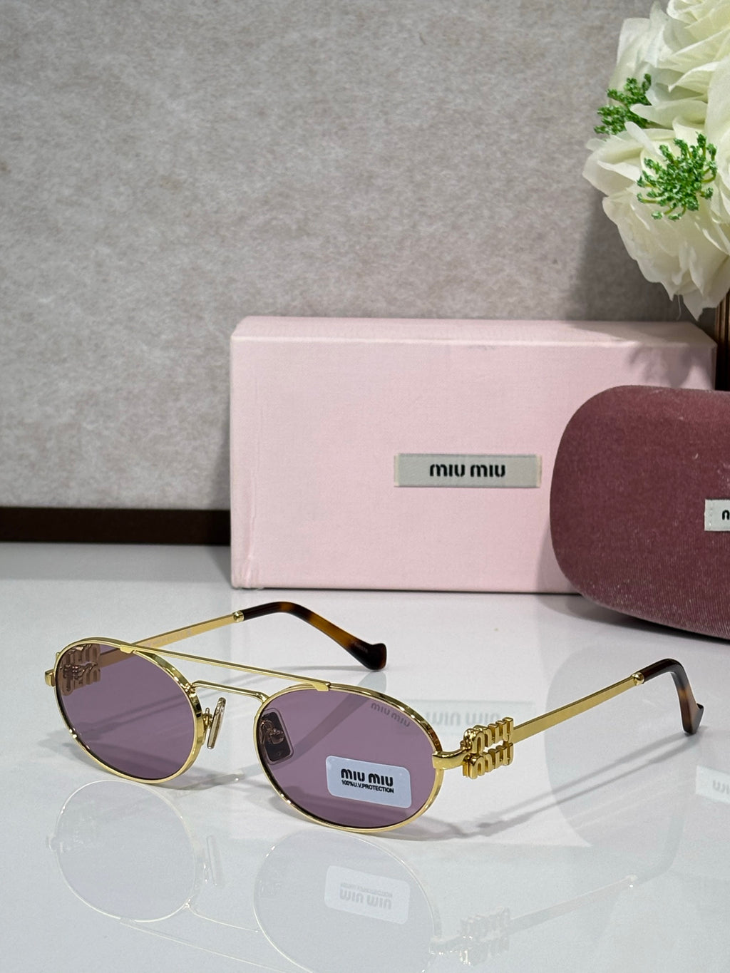 Gold metal round sunglasses with purple-tinted lenses and black temple tips