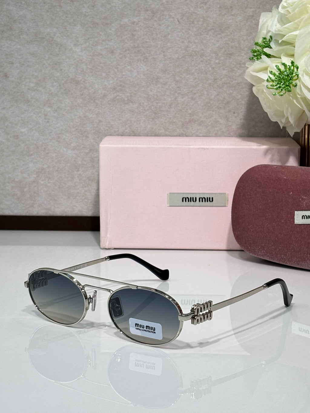 Silver metal round sunglasses with dark lenses and black temple tips