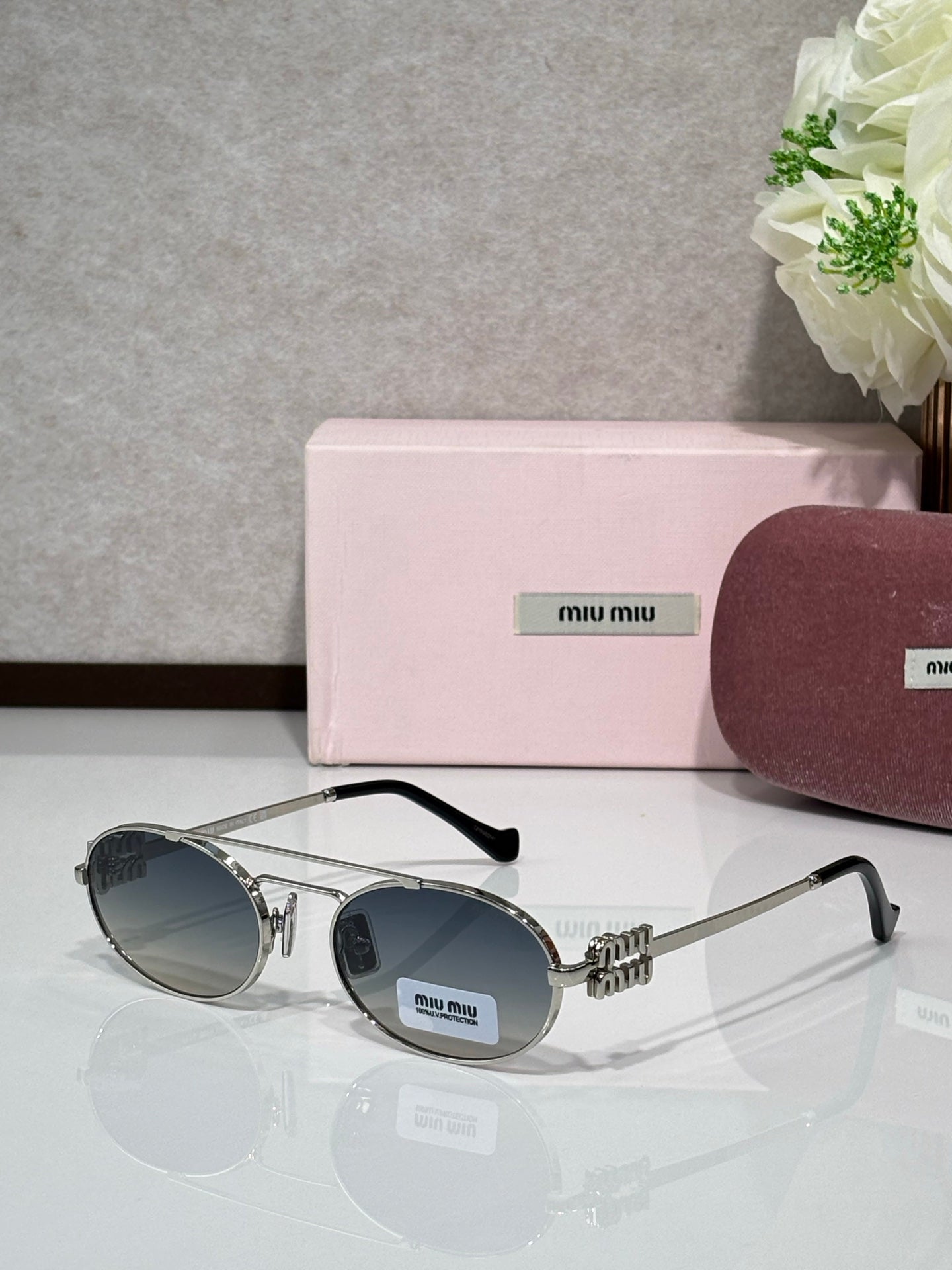 Silver metal round sunglasses with dark lenses and black temple tips