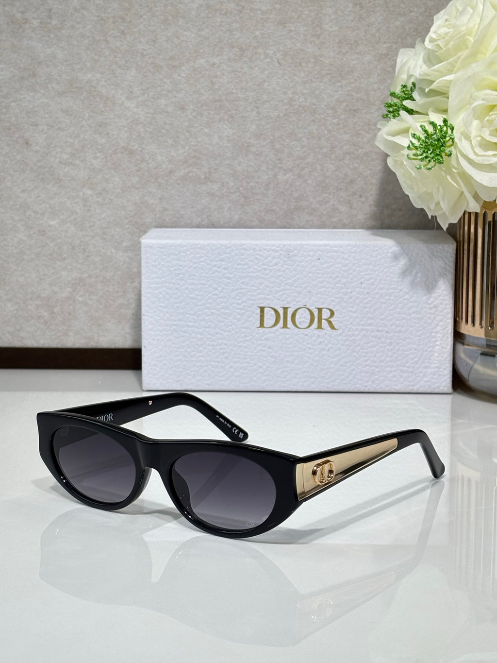 Dior sunglasses with black round frames and dark lenses, gold temple hardware