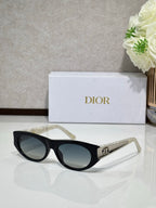 Dior sunglasses with black round frames, dark lenses, and gold logo bar on temple