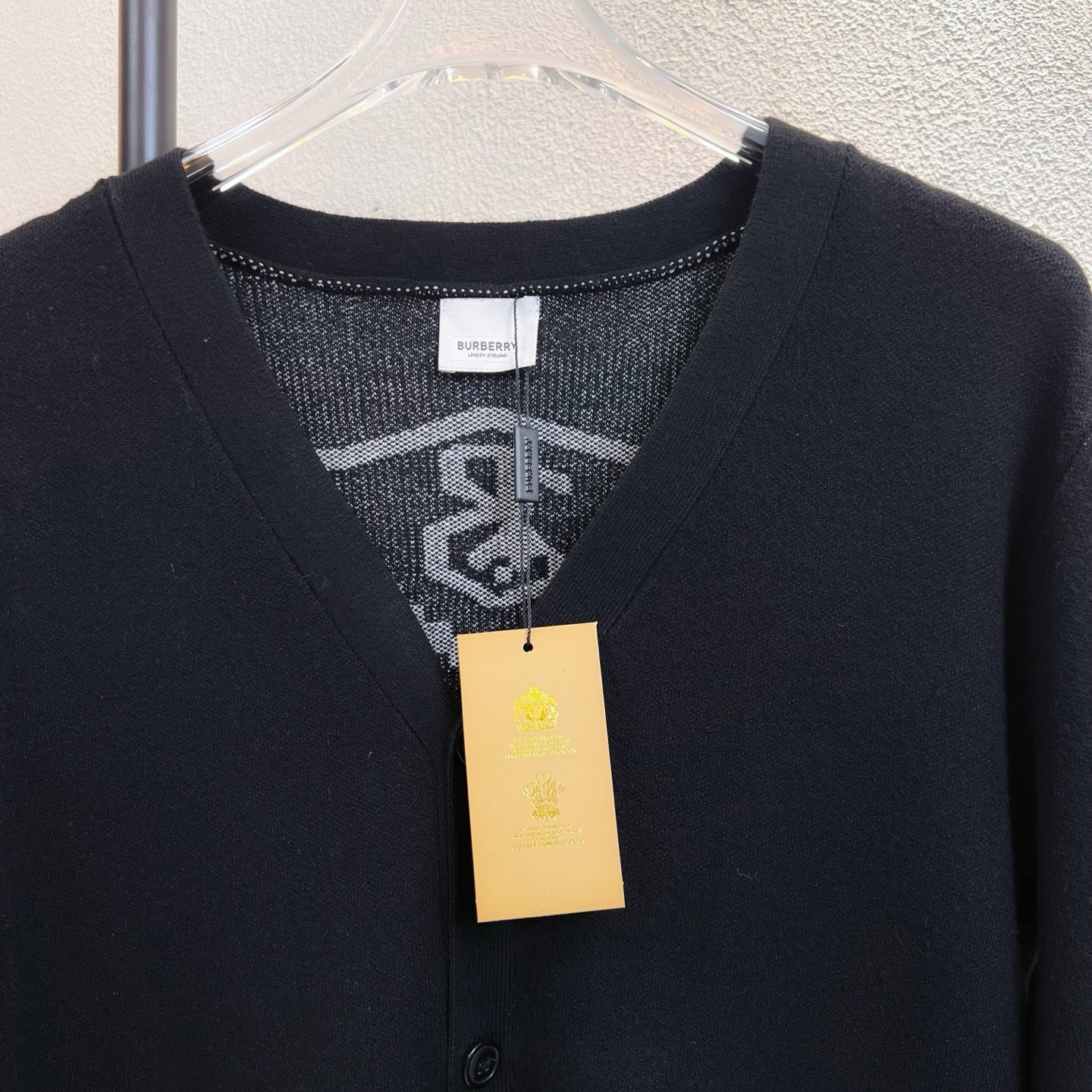 Black V-neck sweater top with Burberry label tag at neckline