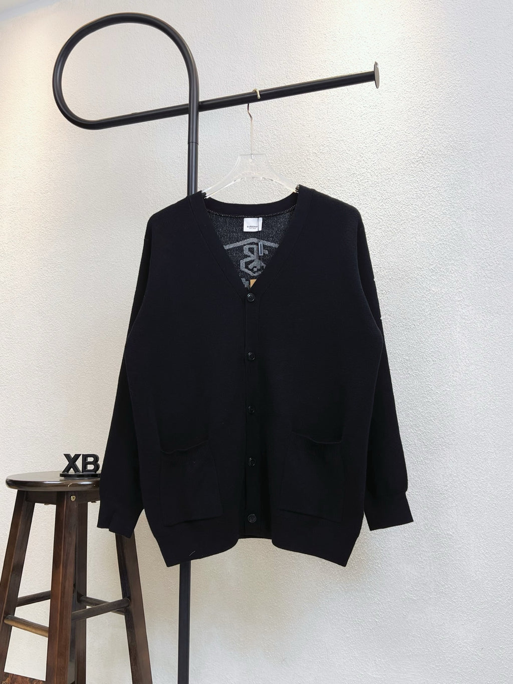 Black cardigan with V-neck, buttons, and flap pockets
