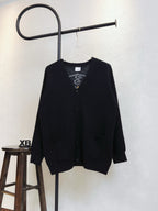 Black cardigan with V-neck, buttons, and flap pockets