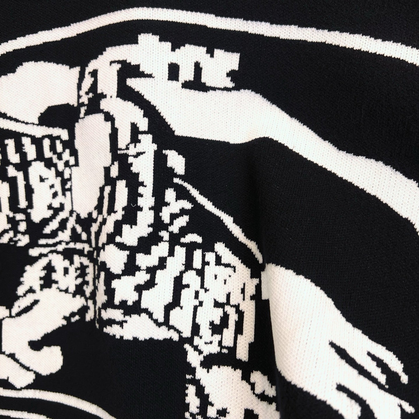 Black sweater with white-and-black patterned horse graphic detail