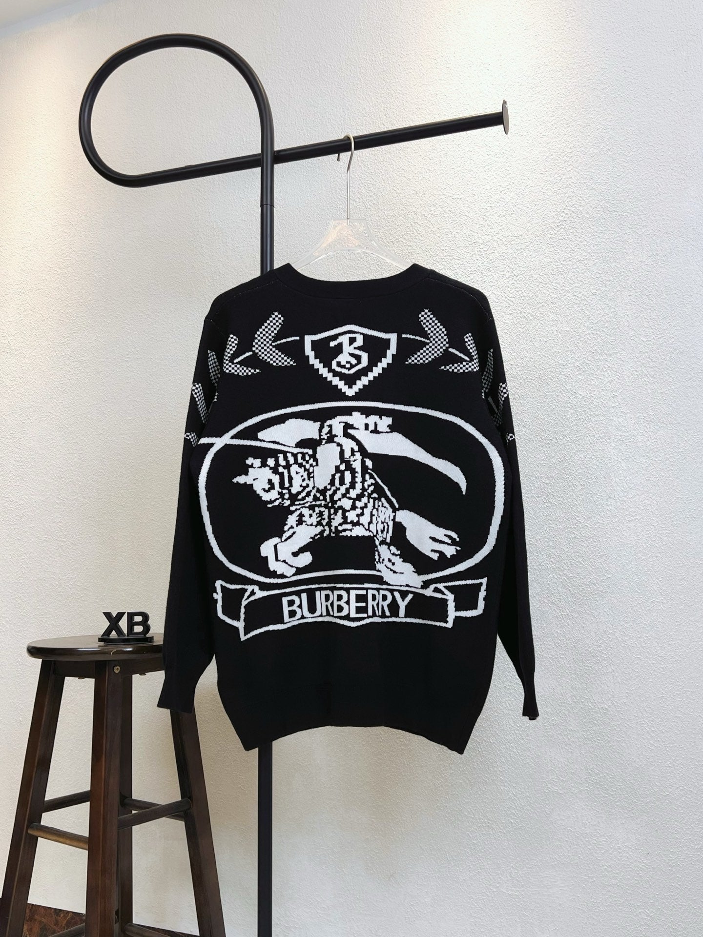 Black sweater with Burberry crest graphic on back and check arrow motifs