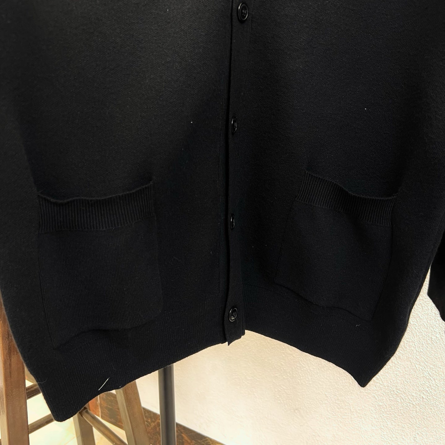 Black knit cardigan with flap pockets and ribbed cuffs