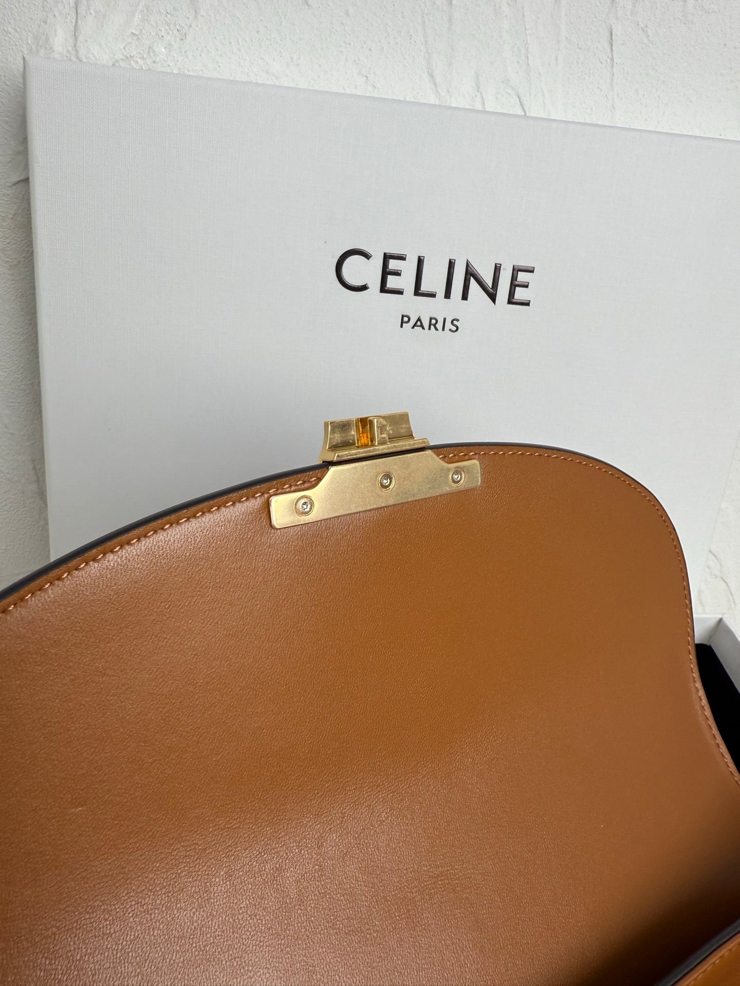 Tan leather bag top with hinged gold-toned closure hardware