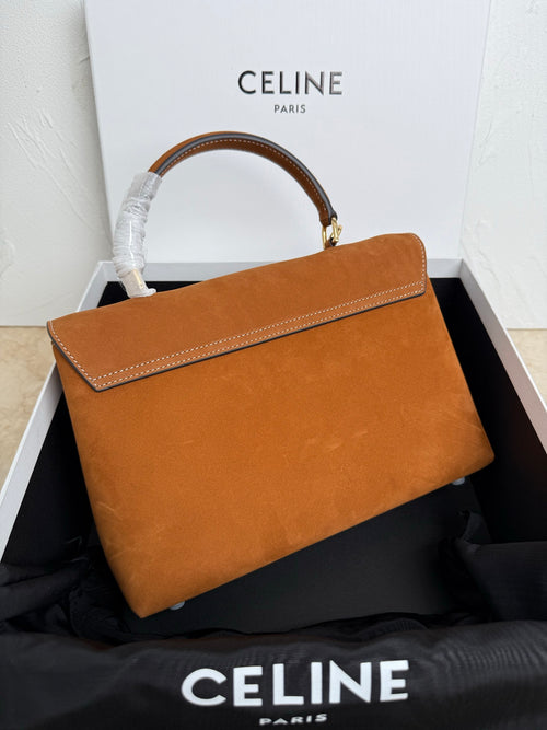 Tan leather handbag with braided handle wrap, gold hardware, and flap closure