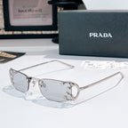 Prada glasses with clear lenses and silver-tone metal frames, curved rectangular design