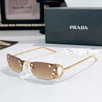 Prada glasses with brown gradient lenses and gold-tone metal frames, curved rectangular design