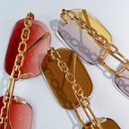 Louis Vuitton sunglasses close-up: red and amber lenses with gold chain frames