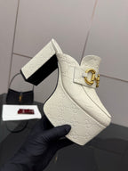 Gucci women’s platform wedge mules, cream embossed upper with gold buckle clasp