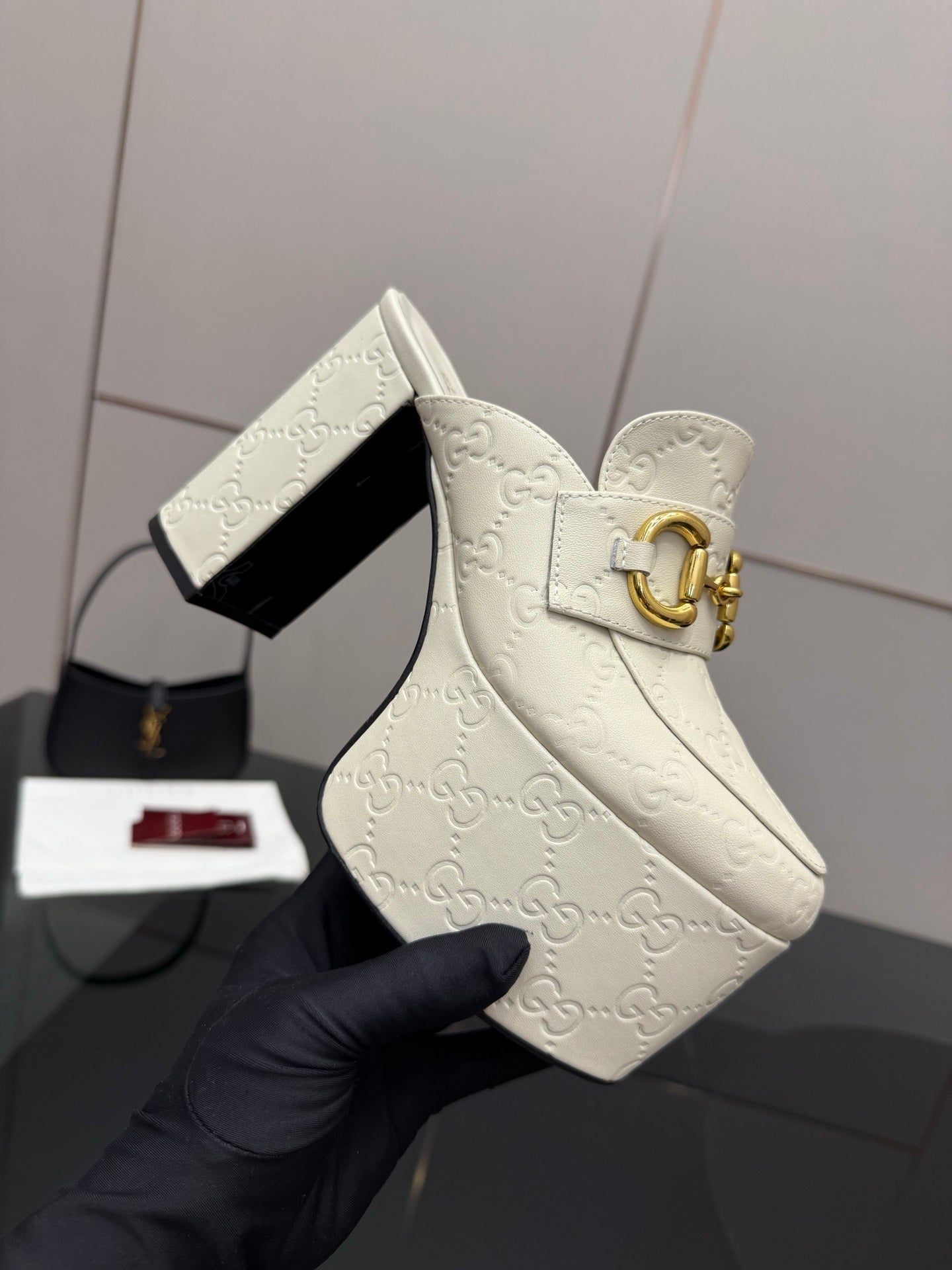 Gucci women’s platform wedge mules, cream embossed upper with gold buckle clasp