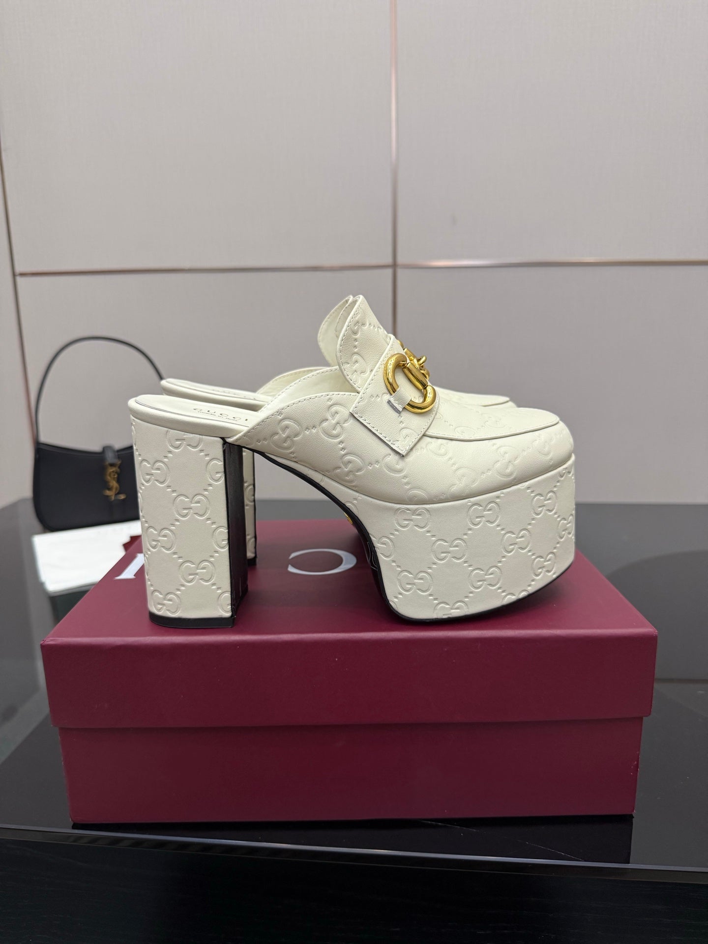 Gucci women’s platform mules, cream slide with thick embossed sole and gold buckle