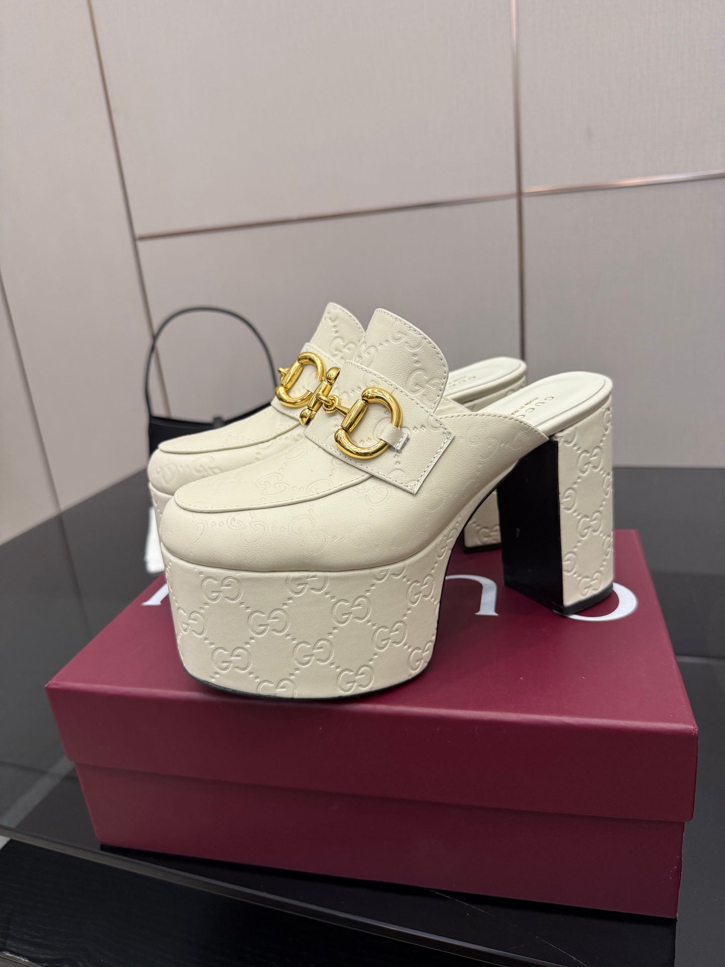 Gucci women’s platform mules, cream embossed leather, gold buckle on open heel