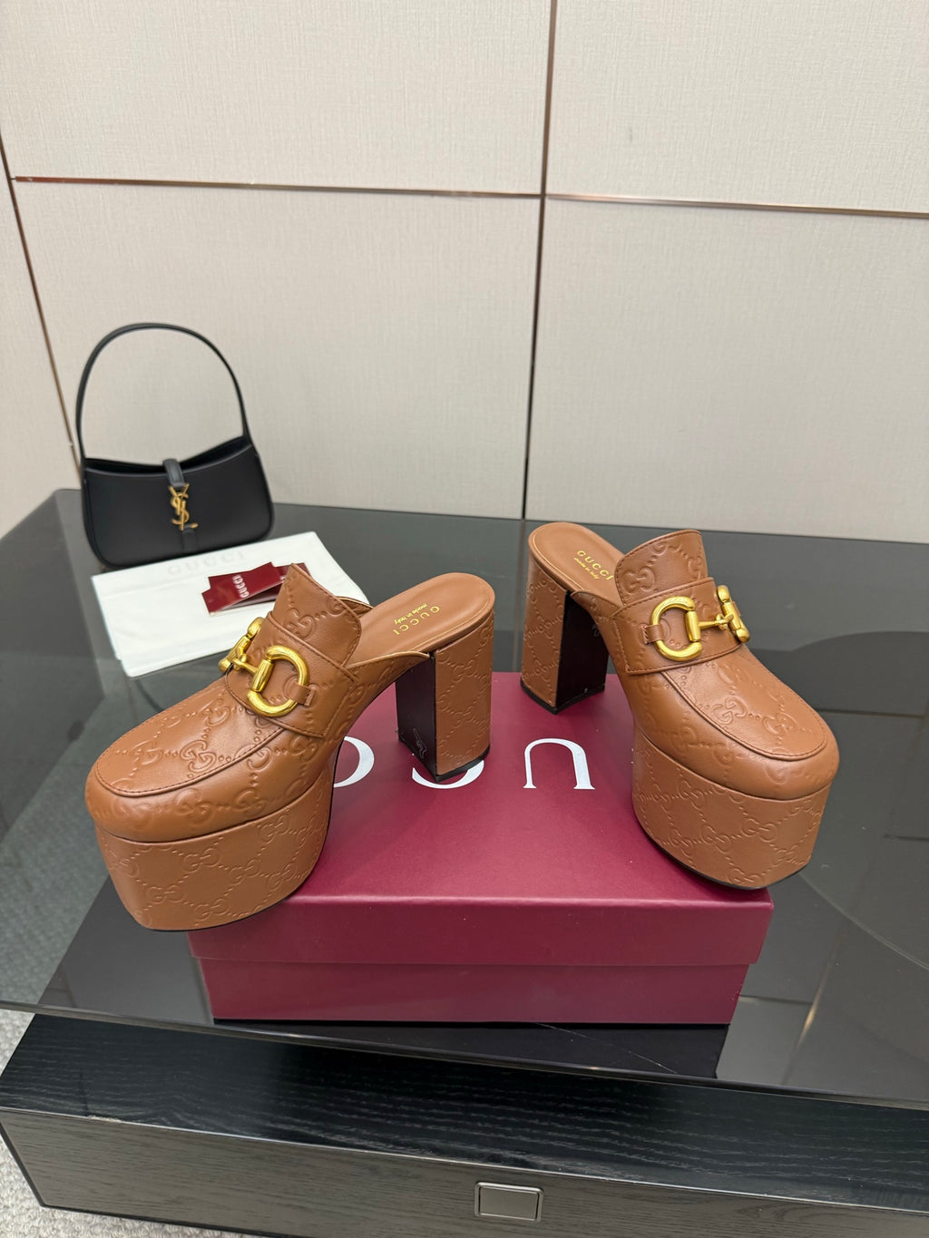 Pair of tan/brown embossed platform mule sandals with chunky block heels and gold buckle