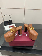 Pair of tan/brown embossed platform mule sandals with chunky block heels and gold buckle