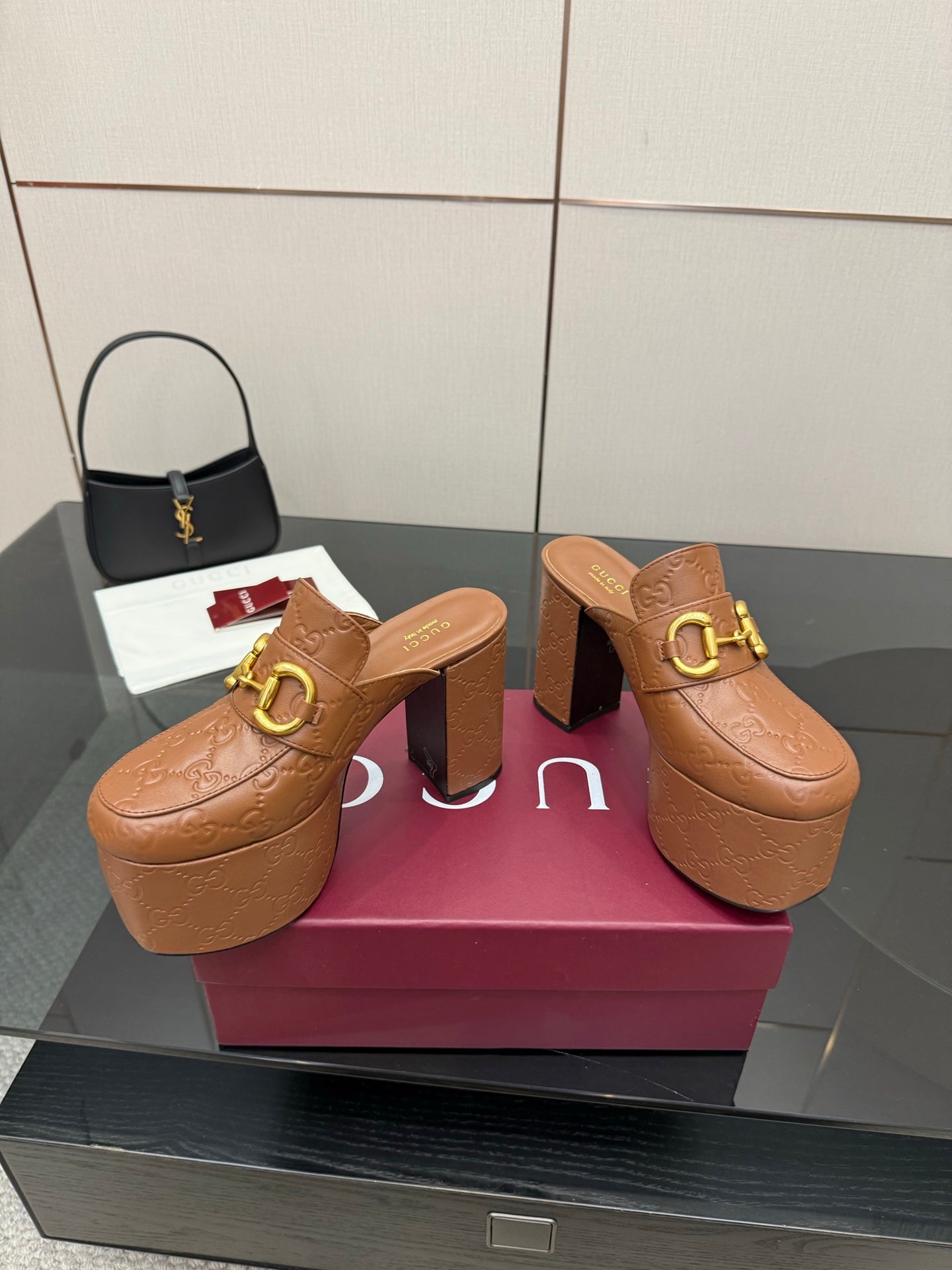 Pair of tan/brown embossed platform mule sandals with chunky block heels and gold buckle