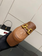 Tan/brown embossed mule sandal with gold double-buckle top strap on a platform sole