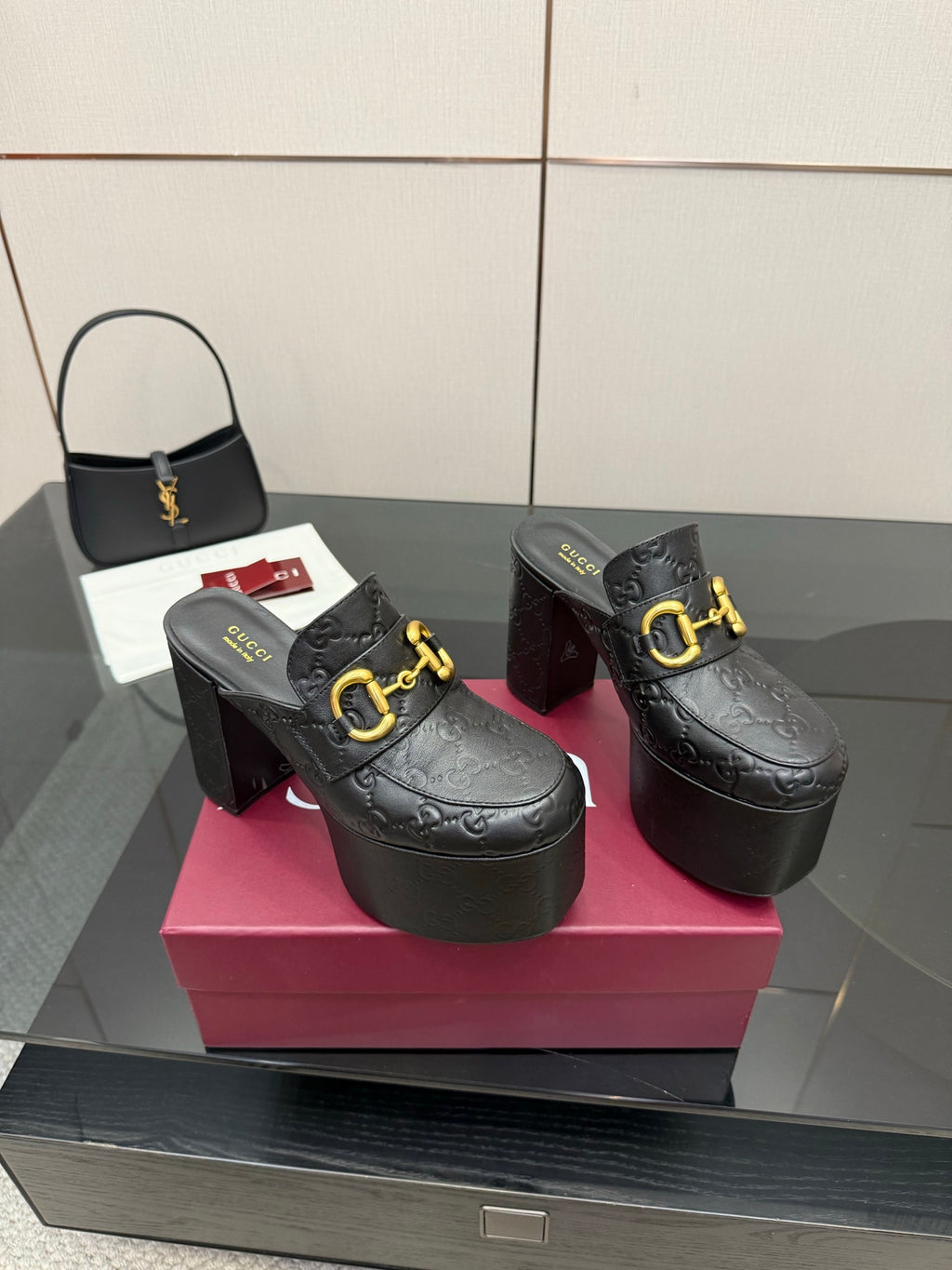 Black Gucci platform mules with gold buckle strap and tall block heel