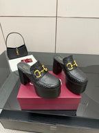 Black Gucci platform mules with gold buckle strap and tall block heel