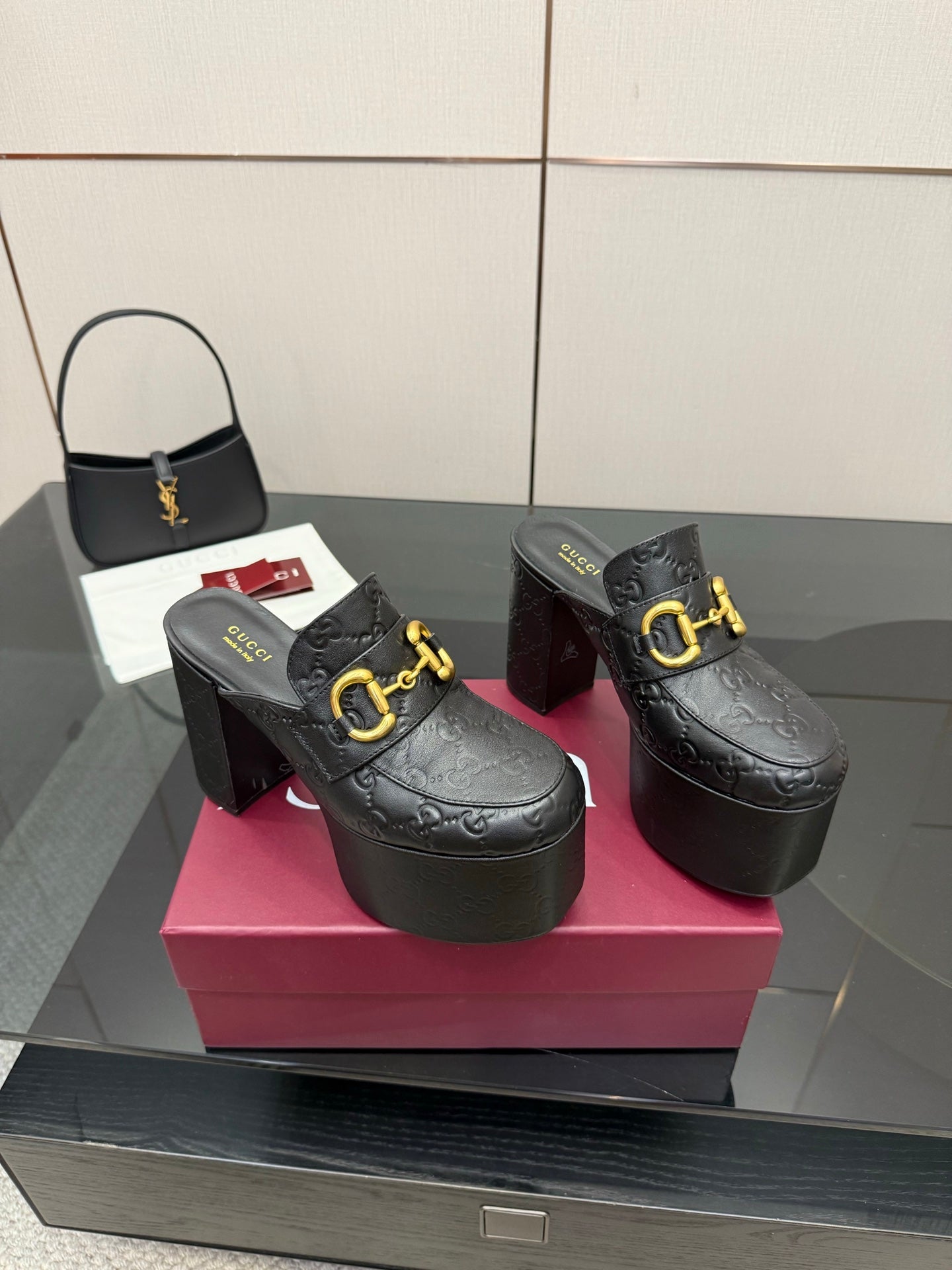 Black Gucci platform mules with gold buckle strap and tall block heel