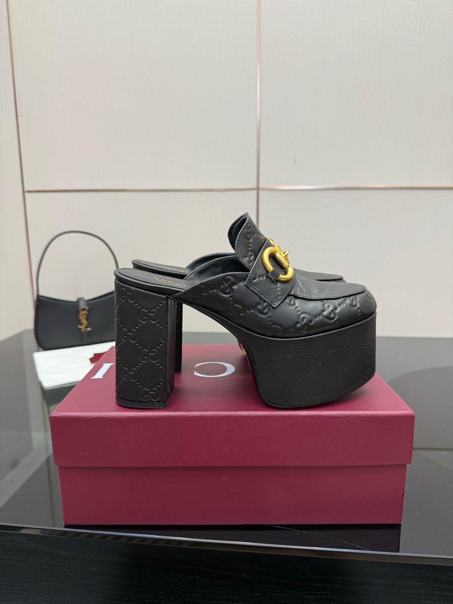 Black Gucci platform mule with gold buckle strap and high block heel