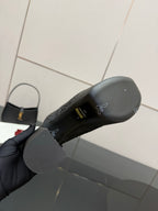 Bottom view of black Gucci platform mule showing outsole and logo pattern