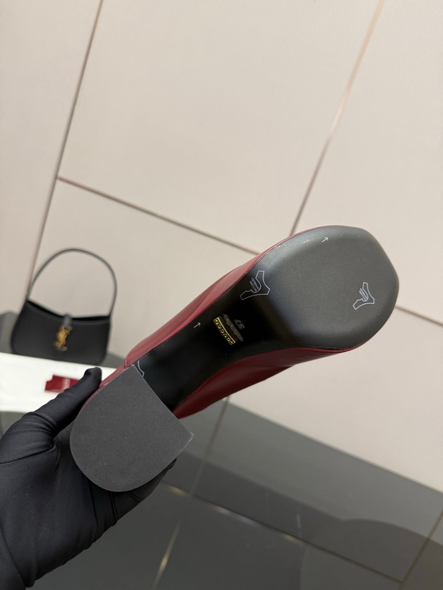 Burgundy Gucci mule outsole with embossed logo on the heel