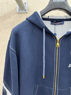 Navy hooded zip jacket with drawstrings, front pocket, and logo on chest