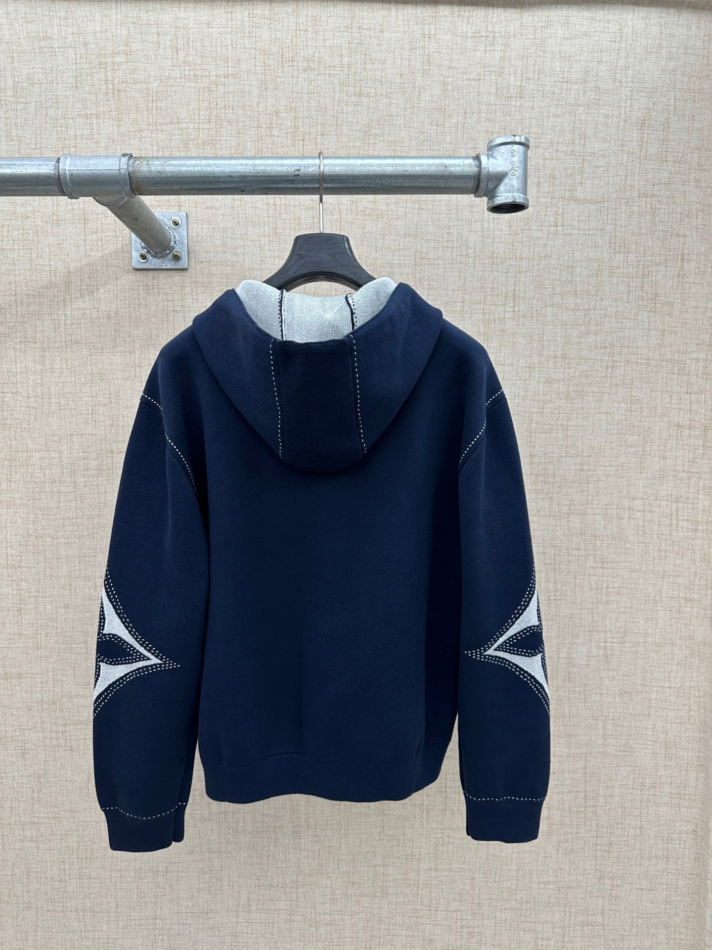 Navy back view hoodie with hood and long sleeves, graphic sleeve panels