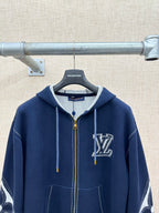 Navy zip-up hoodie with hood, drawstrings, and chest logo; graphic sleeve accents