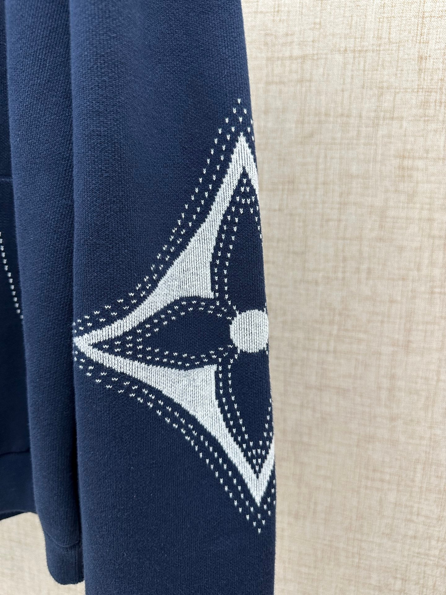 Navy hoodie sleeve with white geometric graphic and dotted pattern