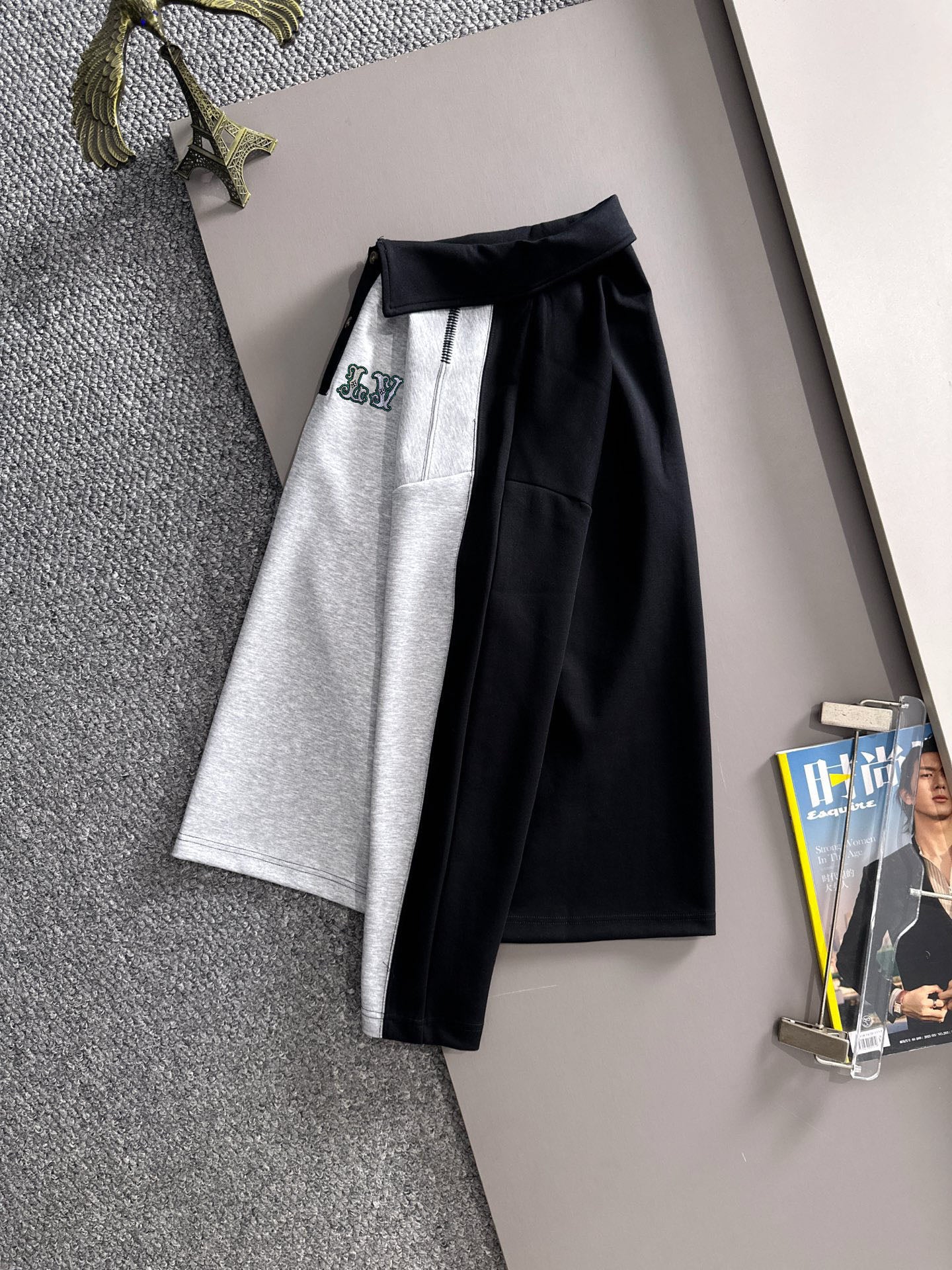 Two-piece outfit: grey skirt with black panel and matching long-sleeve top, hanging