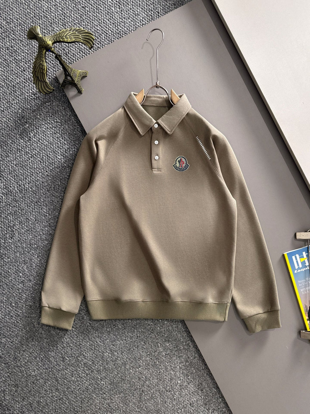 Beige long-sleeve polo with button placket, collar, and chest logo patch
