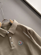 Beige long-sleeve polo with pointed collar, button placket, and embroidered chest crest