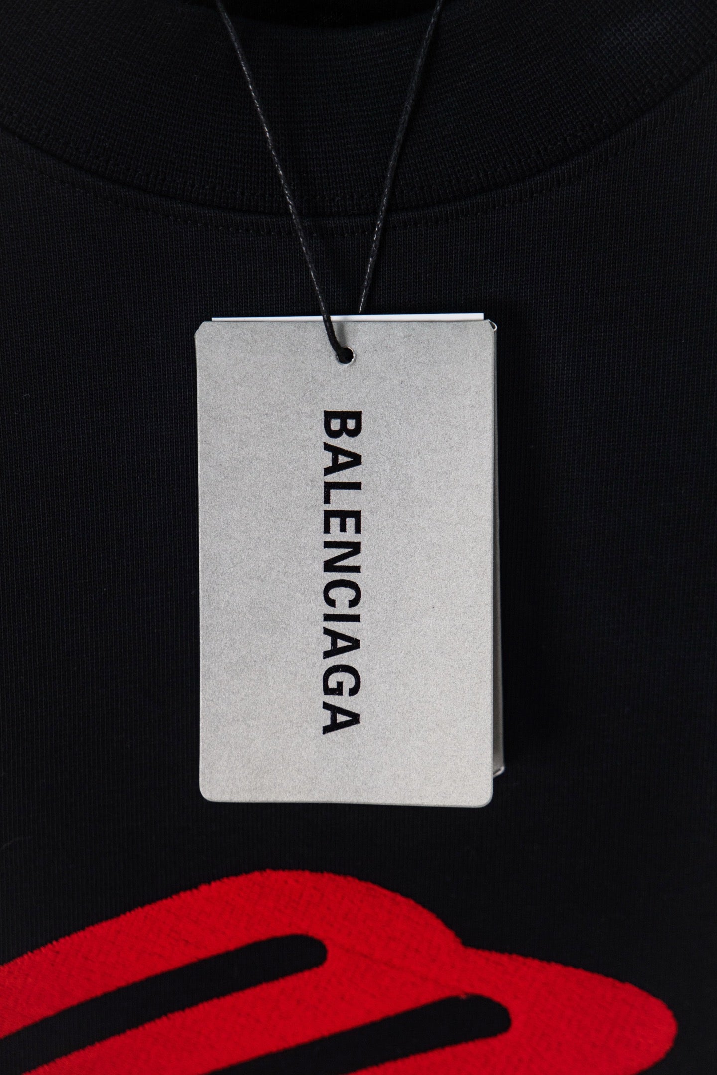 Black long-sleeve T-shirt with Balenciaga paper hang tag