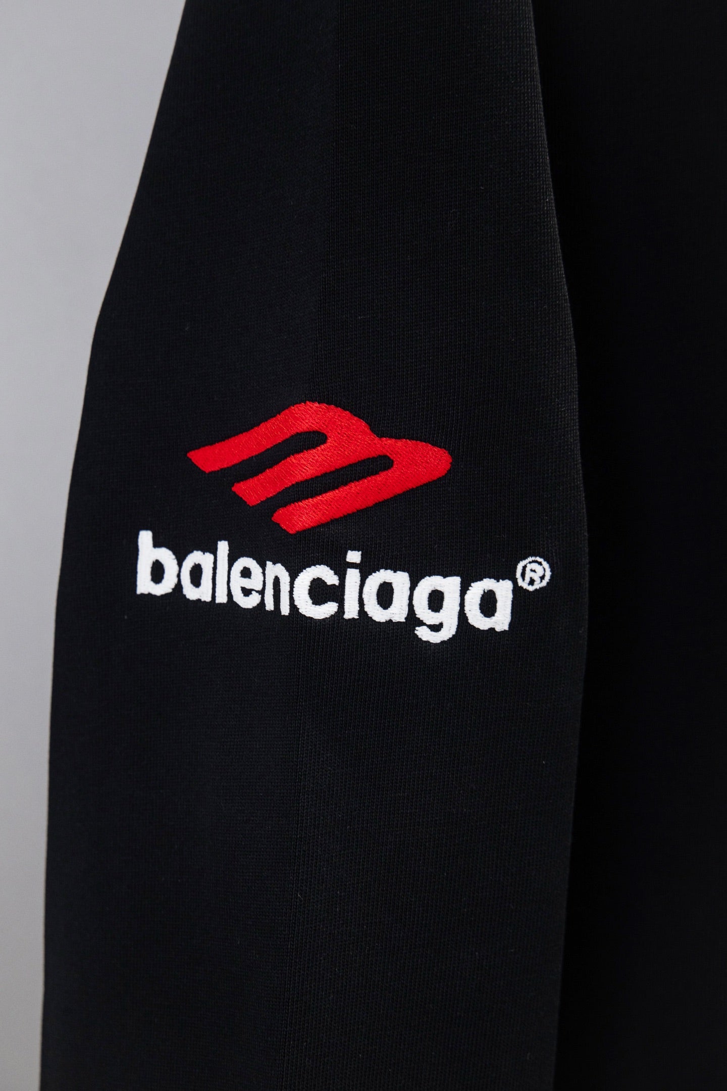 Black long-sleeve T-shirt with red Balenciaga logo on sleeve